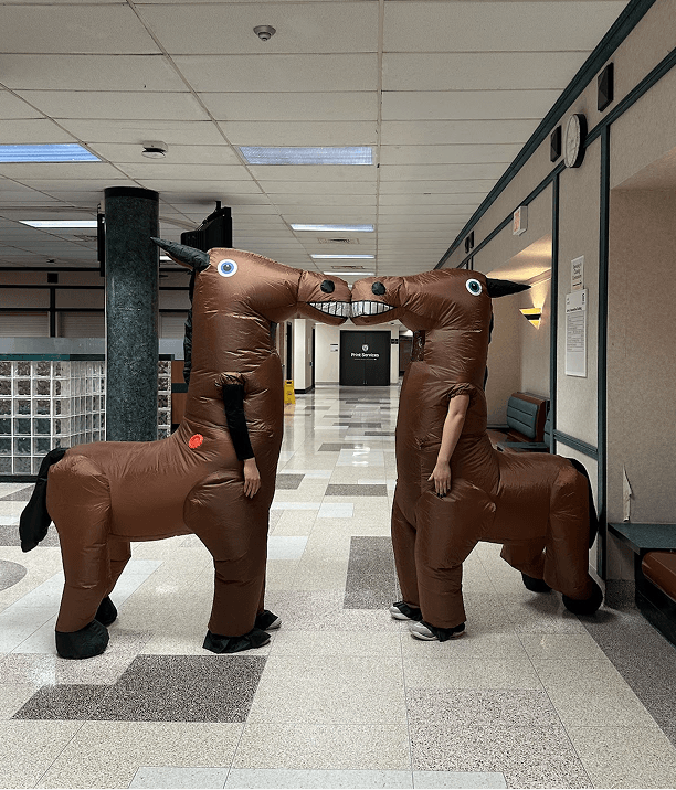 Friends in inflatable costumes in a hallway